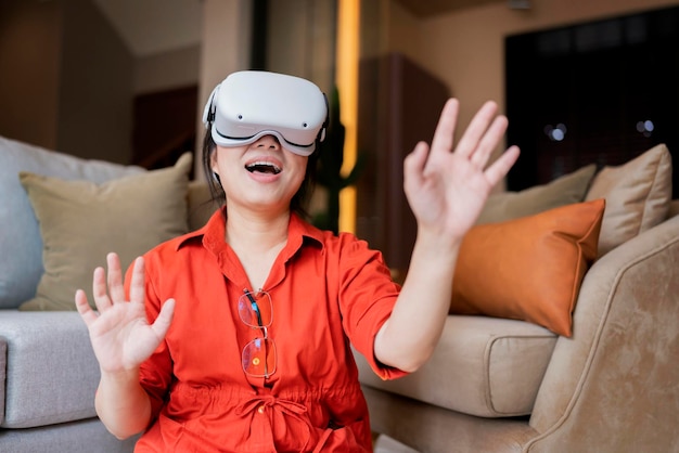 Exitiedは、3D仮想ゲームの未来的な体験をお楽しみください若いアジアの女性は、オンラインの楽しいゲームを打ち負かすために、シミュレーションデジタル世界の手のジェスチャーを自分で制御するVRヘッドセット技術を着用しています
