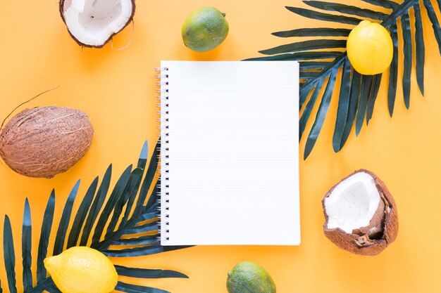 Exotic fruits with blank notebook on table