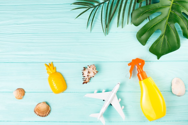 Exotic travel composition with shells, toys and green leaves