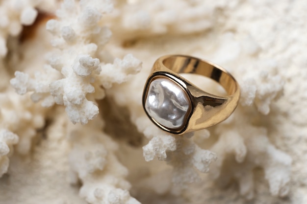 Foto gratuita anello d'oro costoso visualizzato su sfondo di corallo bianco