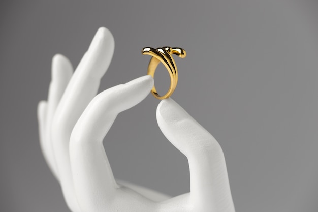 Expensive golden ring with human hand stand display