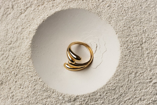 Free photo expensive golden ring with white powder background