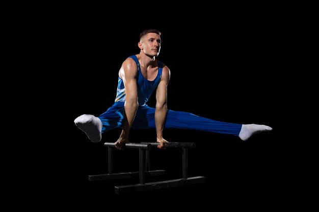 経験。ジムでの筋肉質の男性体操選手のトレーニング、柔軟でアクティブ