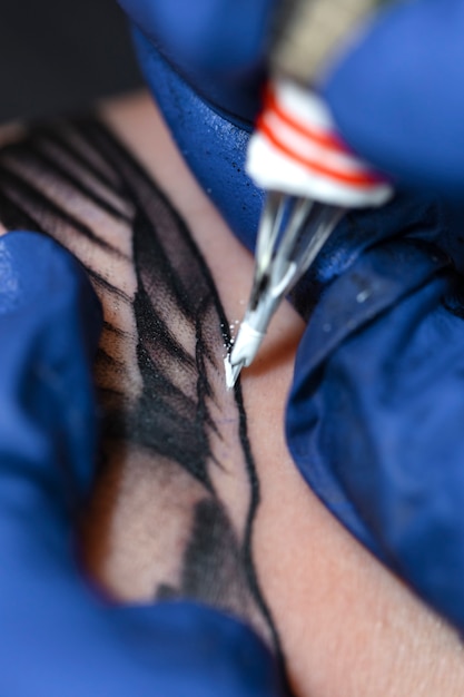 Опытный тату-мастер, работающий над клиентской татуировкой