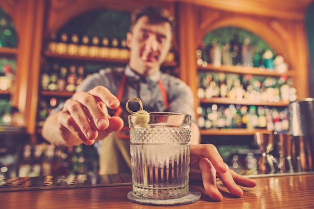 Опытный бармен делает коктейль в ночном клубе.