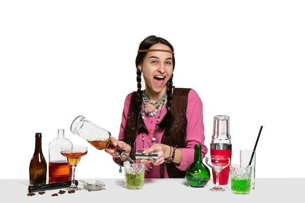 Expert female barman is making cocktail at isolated on white wall.