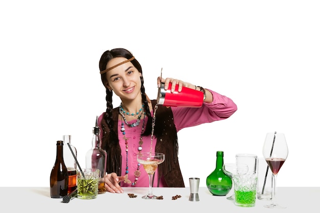 Expert female barman is making cocktail at studio isolated on white wall