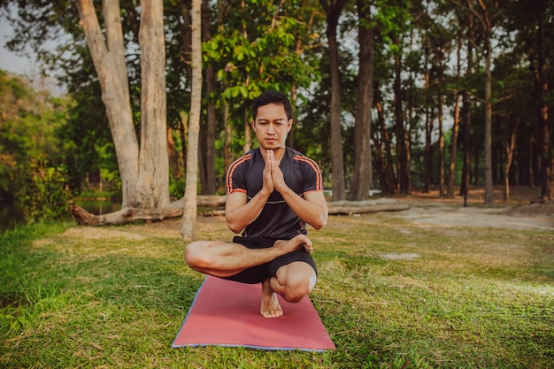 Esperto di praticare lo yoga nel parco