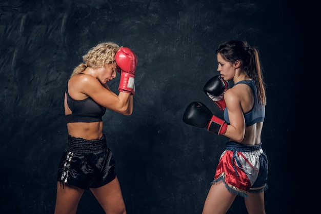 Опытный тренер и ее молодой ученик тренируются по боксу в боксерских перчатках.