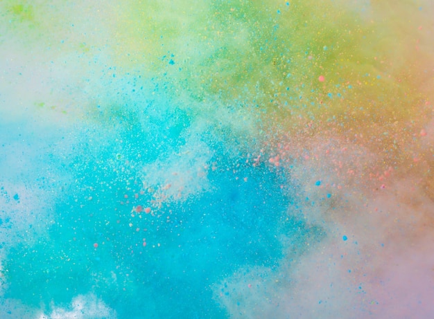 Free photo explosion of colored powder on white background