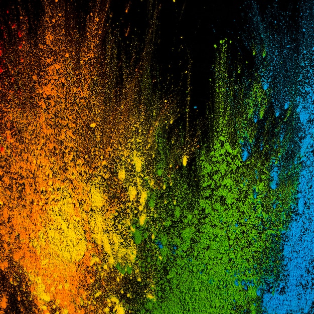 Free photo explosion of holi colors over black surface