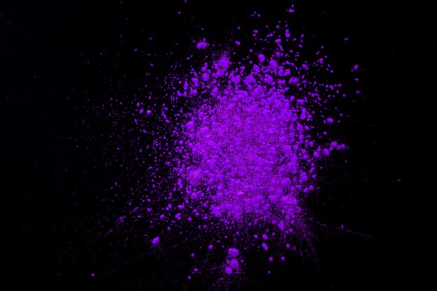 Explosion of purple dry color over black background