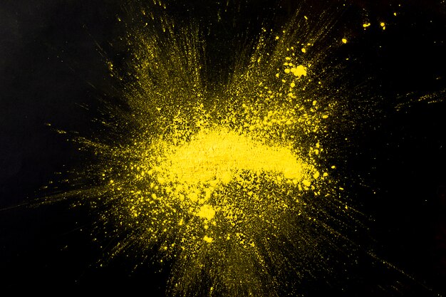 Explosion yellow colored powder on black surface