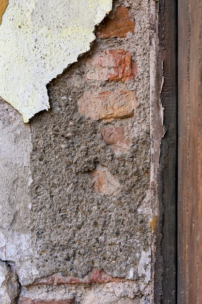 コンクリート表面が剥離した露出したレンガの壁