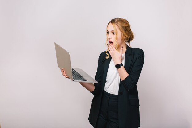 Expressing true astonished emotions of young pretty blonde office woman working with laptop. Being busy, looking for solutions, surprised, stylish look
