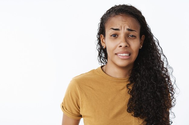Выразительная афро-американская девушка в коричневой футболке