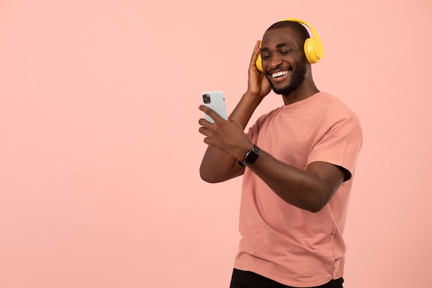 Free photo expressive african american man listening to music on headphones