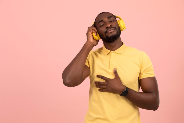 Free photo expressive african american man listening to music on headphones