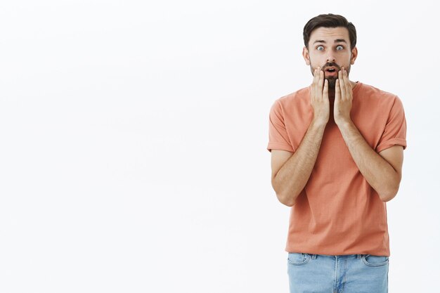 オレンジ色のTシャツで表現力豊かなひげを生やした男