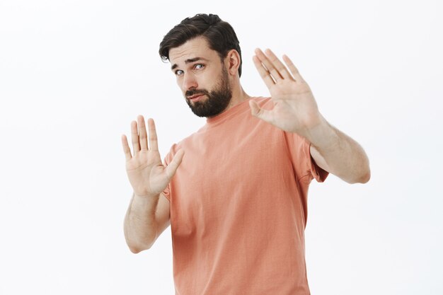 オレンジ色のTシャツで表現力豊かなひげを生やした男