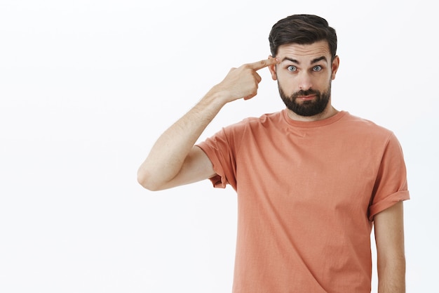 オレンジ色のTシャツで表現力豊かなひげを生やした男