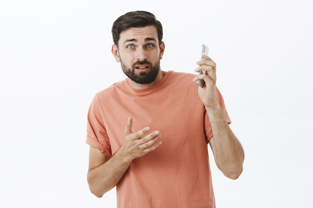 オレンジ色のTシャツで表現力豊かなひげを生やした男