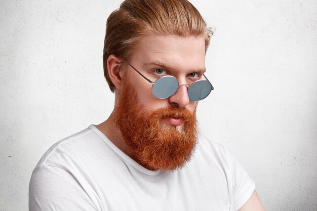 Expressive blond man with ginger beard and sunglasses