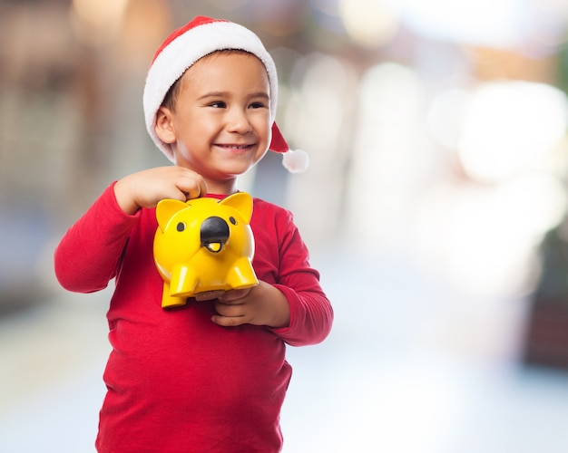 Free photo expressive boy holding his piggybank