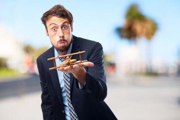 Expressive executive with a wooden plane on hand