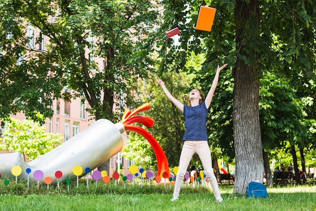 Expressive girl throwing up books