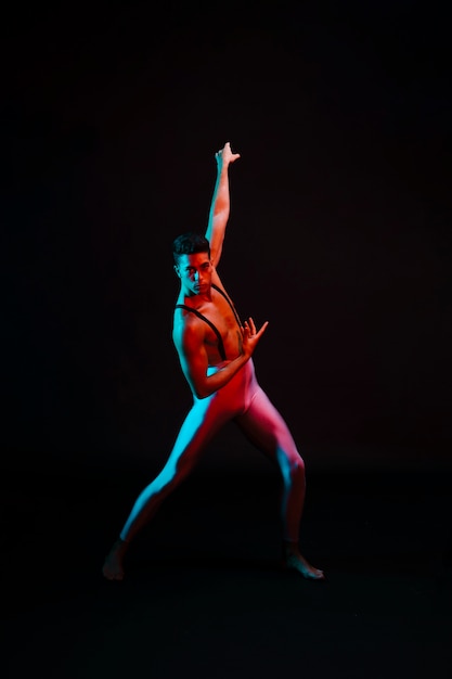 Бесплатное фото Выразительный танцор балета в купальнике, стоящий в центре внимания