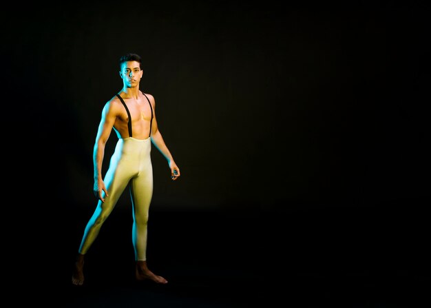 Expressive male ballet dancer performing in spotlight