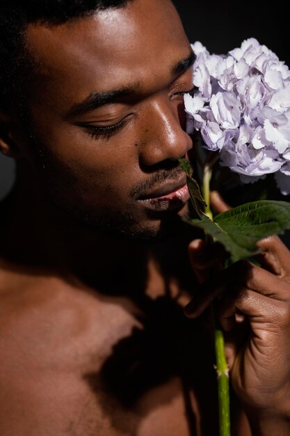 Expressive man posing with flower close-up