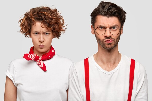 Expressive man and woman in white T-shirts posing