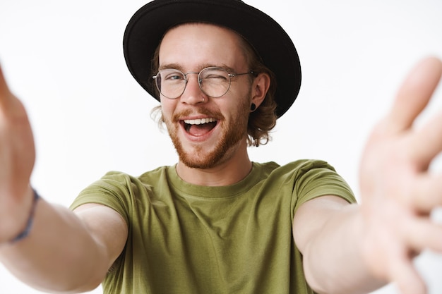 Uomo barbuto rosso espressivo con un cappello