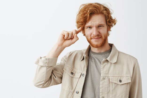 Expressive redhead guy in beige shirt