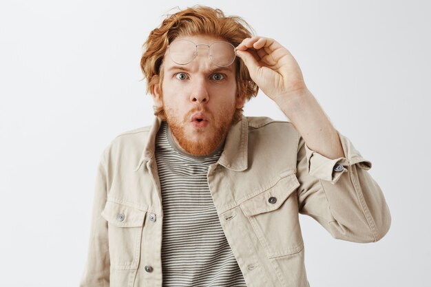 Expressive redhead guy in beige shirt