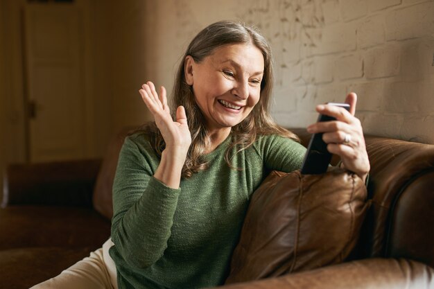 屋内でポーズをとる表情豊かな年配の女性