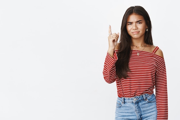 An expressive teenage girl in a striped blouse