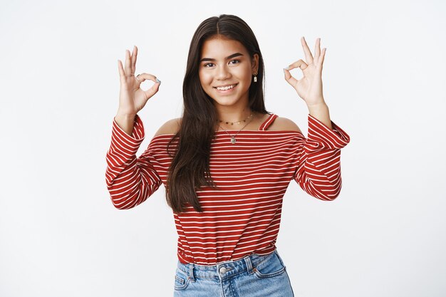 An expressive teenage girl in a striped blouse