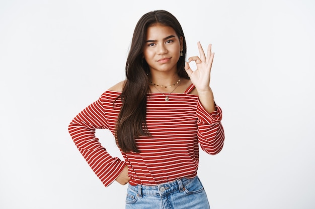 An expressive teenage girl in a striped blouse