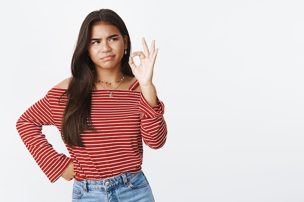 An expressive teenage girl in a striped blouse