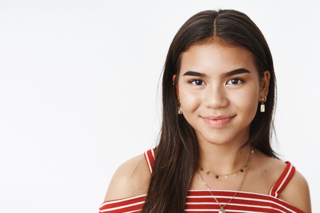 An expressive teenage girl in a striped blouse