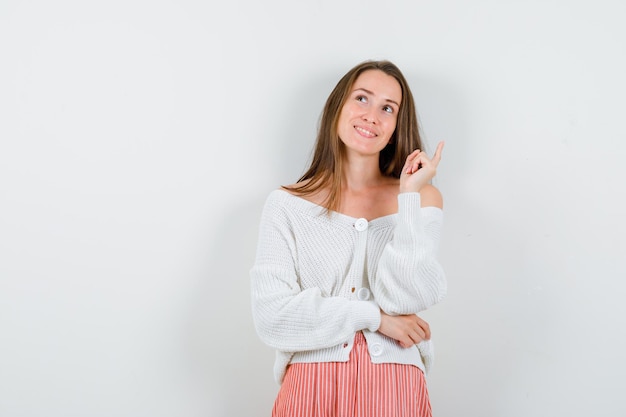 スタジオでポーズをとる表情豊かな若い女性