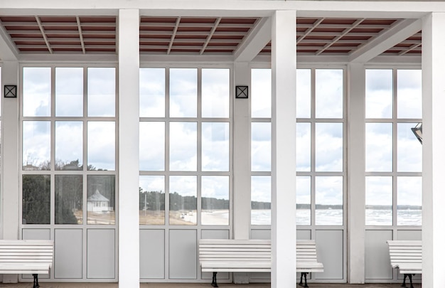 Exterior of a white building with benches overlooking the sea