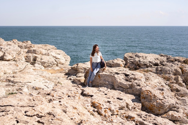 Extra long shot woman sitting on rocks