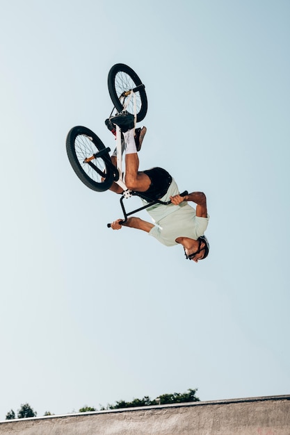 Free photo extreme bicycle rider performing dangerous jumps