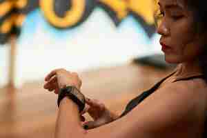 Free photo extreme closeup of asian sportswoman checking pulse with electronic device