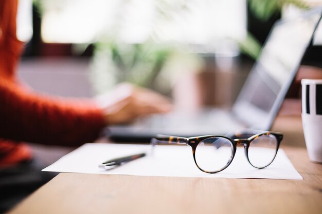 Eyeglasses in desktop of worker