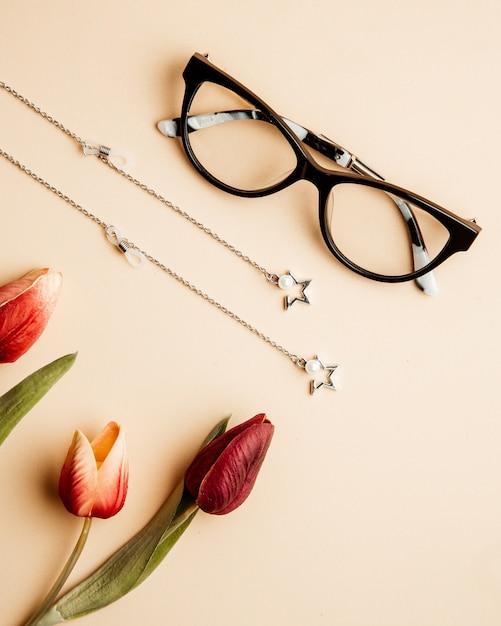 Free photo eyeglasses for women tulips and accessories on table